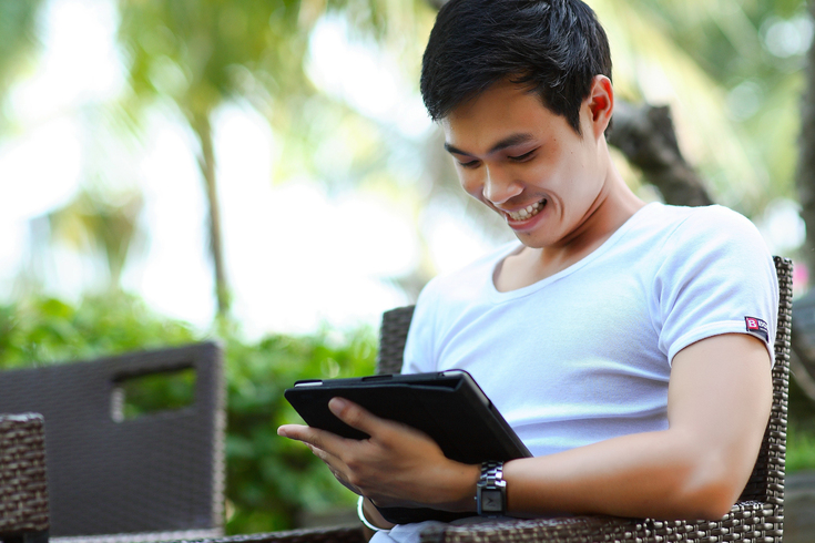 man using his tablet in a park