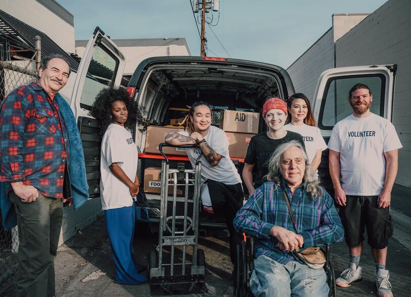 men and women standing around a truck during volunteer event