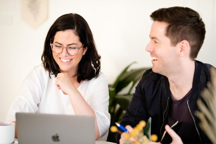 a man and a woman laughing while working together