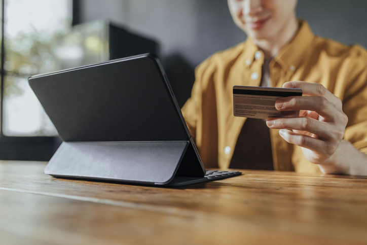 person typing in credit card info on a computer for a donation