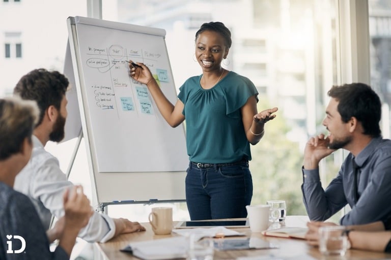 woman points to poster board during business meeting