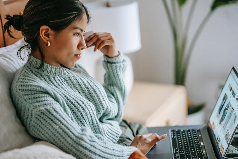 a woman sitting on her couch while working on her computer